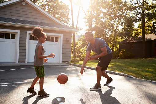 istock Father And Son Playing Basketball On Driveway At Home 904506166