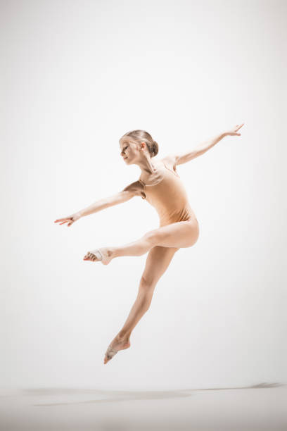 The female teen modern ballet dancer on orange studio background