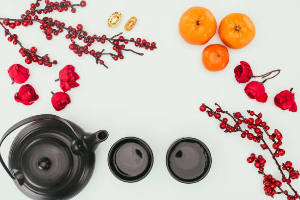 top view of chinese new year composition with tea and branches of berries isolated on white top view of chinese new year composition with tea and branches of berries isolated on white oolong tea stock pictures, royalty-free photos & images