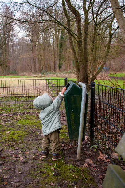 istock Toddler throwing away trash in public park 904510036