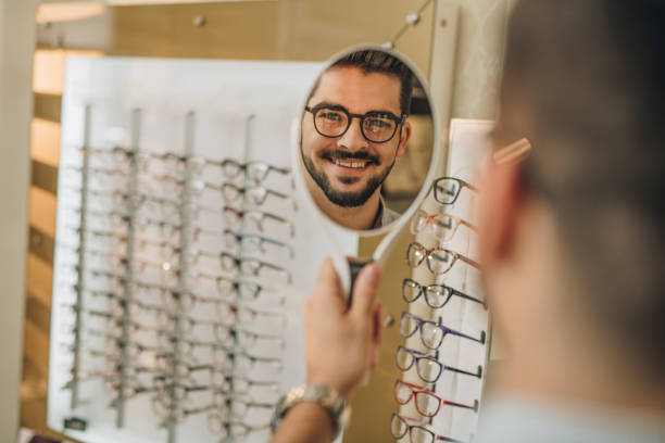 istock Reflection in a mirror of happy man choosing eyeglasses at optician's. 904510040