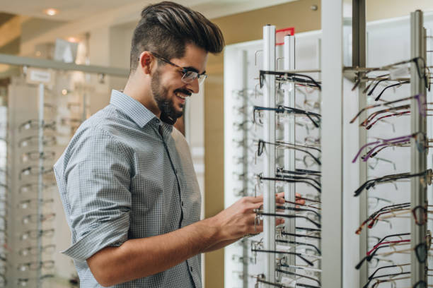 istock Happy man choosing the most suitable eyeglasses in a store. 904513886