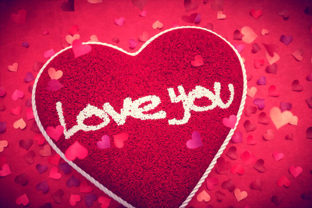 istock Red Knitted Cushion With Falling Petals And A Love Message 904515264