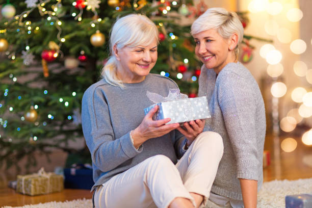 istock Mother and daughter by Christmas tree 904518752