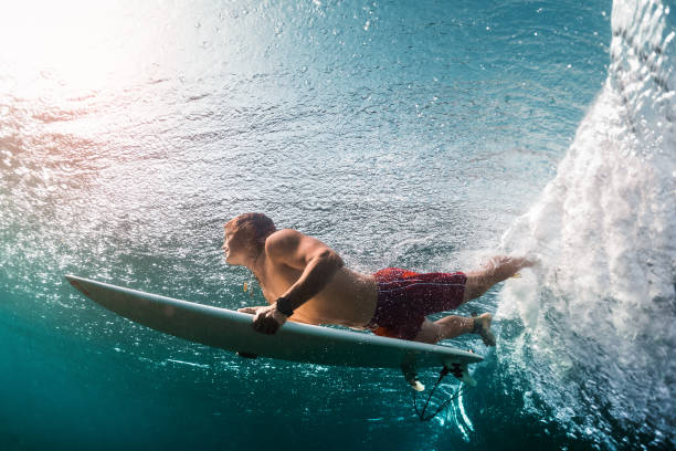 istock Young surfer dives under the ocean wave 904522614