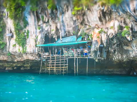 An image of Viking Cave (Tham Phaya Nak), located on Phi Phi Le Island, Krabi, Thailand.  This is a famous travel destination visited by thousands annually.  It is the oldest location that still currently harvests birds nests.  The commodity from the Swift bird, is used for 'birds nest soup' traditionally popular in China.  People climb the caves to harvest the nests made by birds at certain times of year.