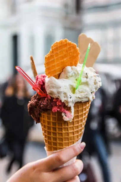 Woman hand holding ice cream in cone.