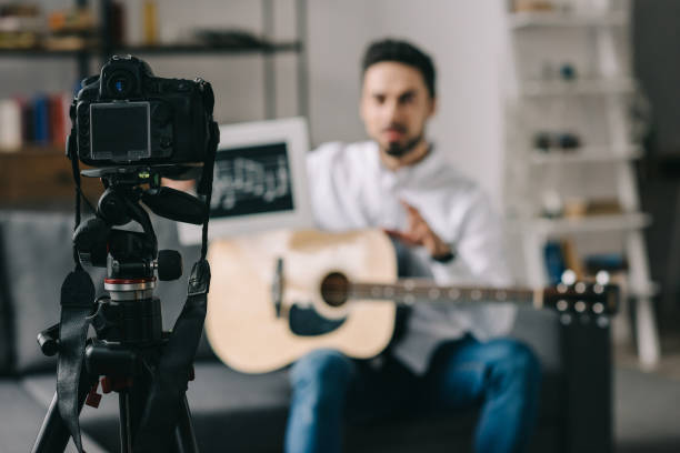 istock music blogger holding notes and guitar in front of camera 904531000