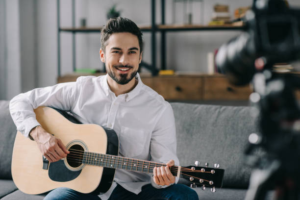 istock handsome music blogger playing acoustic guitar 904531108