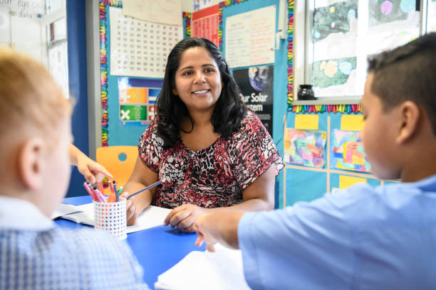 aborigine lehrer in der grundschule arbeiten und mit blick auf schülerinnen und schüler - australische kultur stock-fotos und bilder