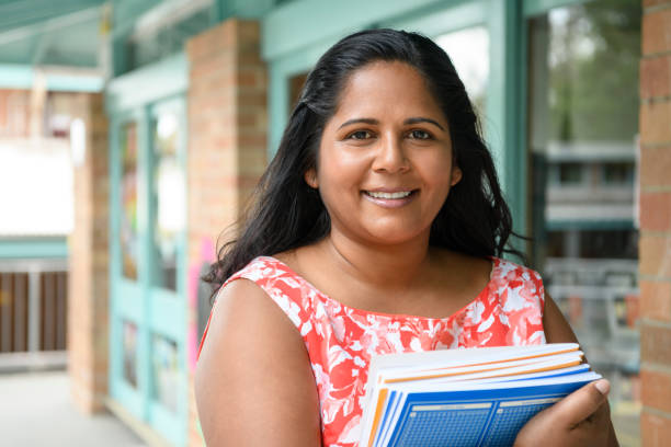 istock Aboriginal woman holding text books outside school 904531408