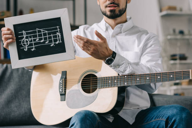 istock cropped image of musician holding notes and guitar 904531466