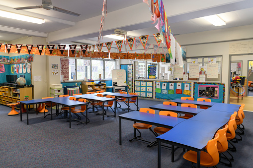 Empty blue desks and orange chairs in primary school, Sydney, Australia.