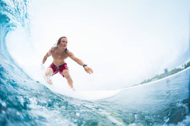 istock Young surfer rides the perfect tropical ocean wave 904531970