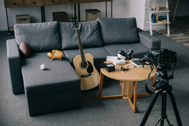 istock acoustic guitar and cameras with gray sofa in empty room 904535798