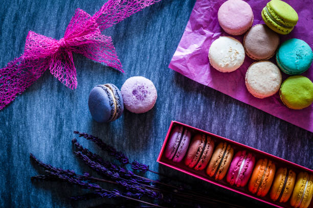 Multi colored macaroons in a box shot on bluish tint table