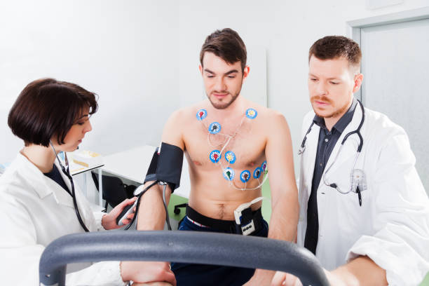 interpretation of the electrocardiogram of young athletes Athlete does a cardiac stress test in a medical study, monitored by the doctor and nurse stress test stock pictures, royalty-free photos & images