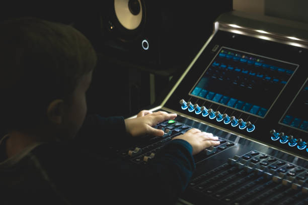 istock Small boy adjusting sound on audio mixer in recording studio. 904545186