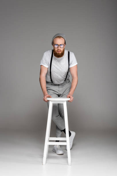 istock man in eyeglasees leaning at stool and looking at camera 904554820