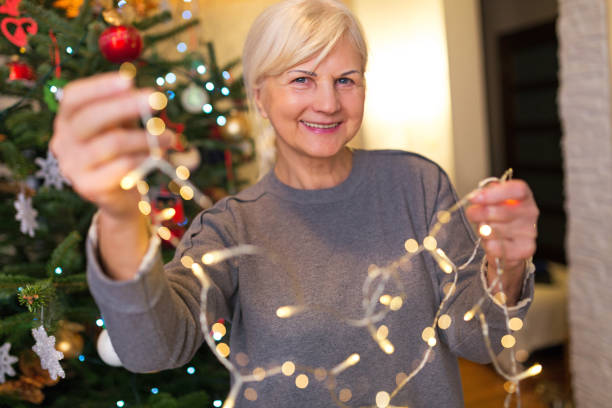 istock Senior woman holding Christmas lights 904557792