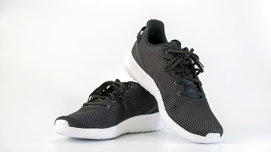Black sneakers running shoes isolated on white background.