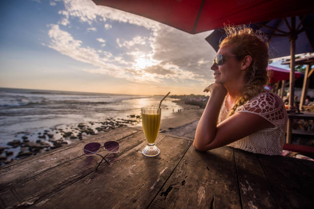 istock Young woman drinking smoothie on the beach. 904558724