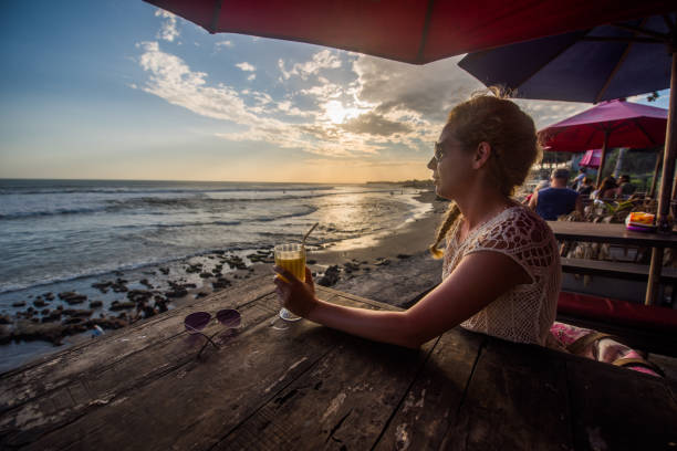 istock Female drinking mango juice at sunset. 904558972