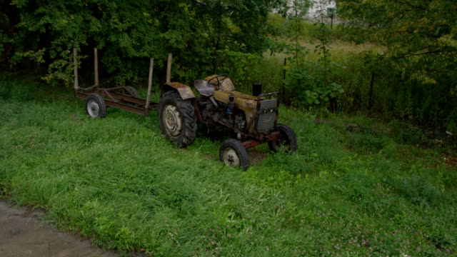 Overgrown farm with old abandoned tractor