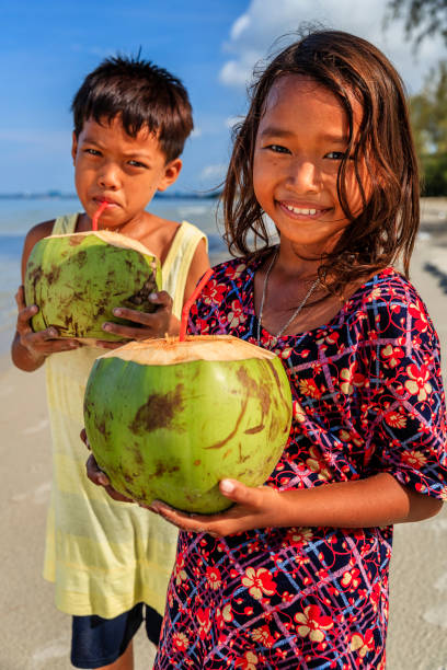 istock Cambodian children drinking coconut milk on the beach, Cambodia 904574776