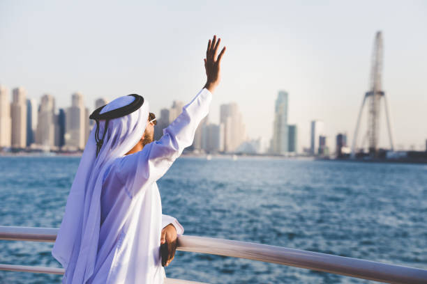 istock Arab man waving towards a passing boat 904582600