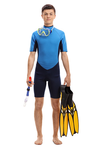 Full length portrait of a teenage boy in a wetsuit with snorkeling equipment isolated on white background