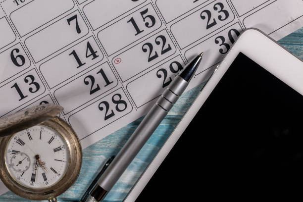 istock Silver pocket watch, Digital tablet computer, calendar and ballpoint pen are placed on a wood 904586146