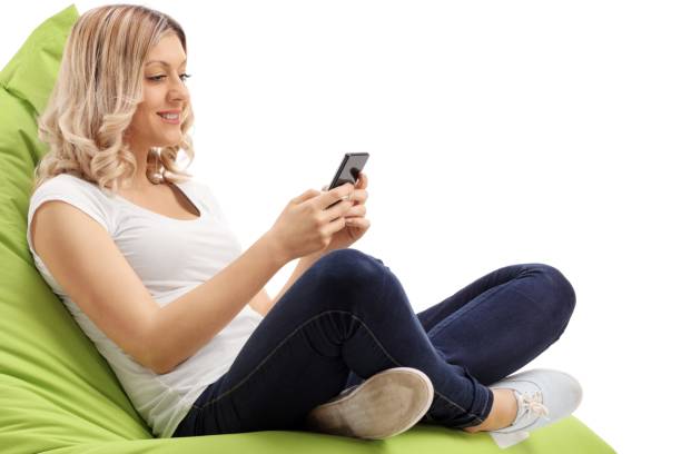 istock Young woman seated on a beanbag using a phone 904586796