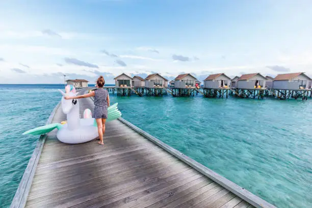 Photo of Asian woman holding pegasus pool float at Maldives.