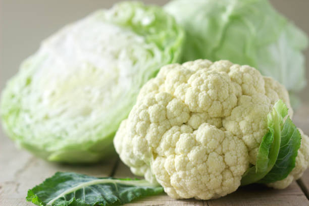 istock Cauliflower and cabbage on a wooden background. Rustic style, selective focus. 904594160