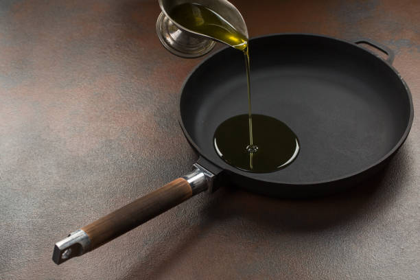 istock Chef pouring oil in frying pan 904594966