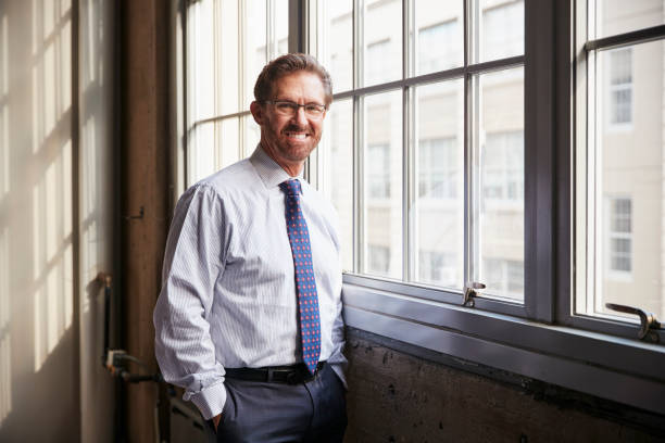 istock Senior businessman with hands in pockets smiling to camera 904595516