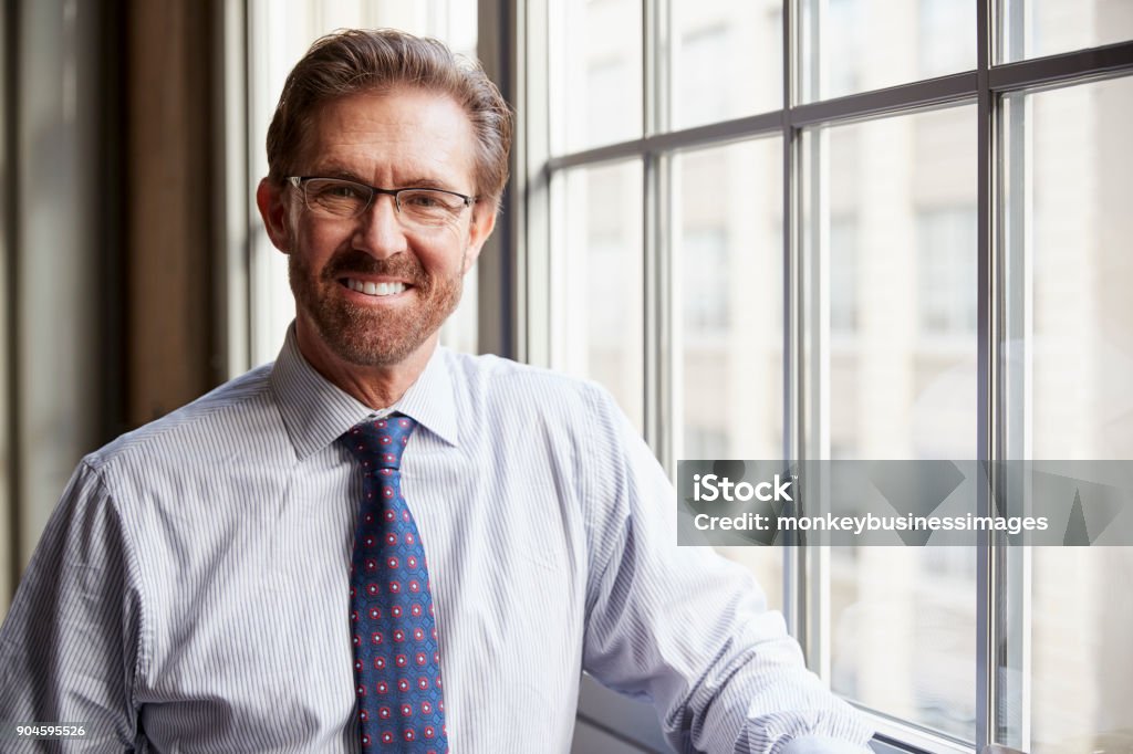 Senior businessman in shirt smiling to camera, close up Adult Stock Photo