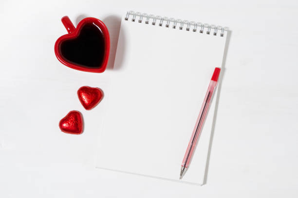 istock cup of coffee, chocolate candy and notepad on white background 904595788