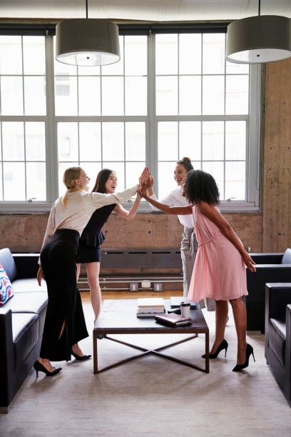 istock Female colleagues high five at a casual meeting, vertical 904595796