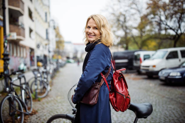 femme souriante à vélo dans la ville au cours de l’hiver - cycling bicycle women city life photos et images de collection