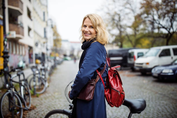 smiling woman with bicycle in city during winter - cycling bicycle women city life imagens e fotografias de stock