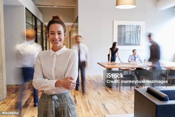 Photo libre de droit de Portrait De Jeune Femme Blanche Dans Un Environnement De Travail Moderne Occupé banque d'images et plus d'images libres de droit de Bureau - Lieu de travail