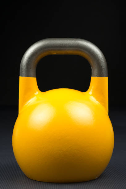 istock Single yellow competition kettlebell on a weight training gym floor 904602960