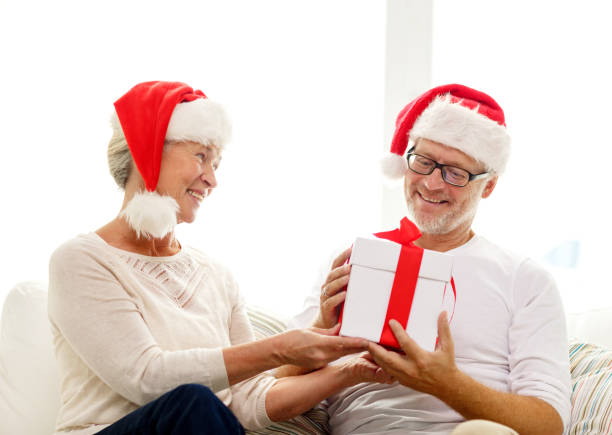 istock happy senior couple in santa hats with gift box 904604142