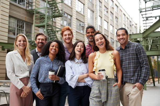 istock Friendly coworkers laugh to camera outside their workplace 904608450