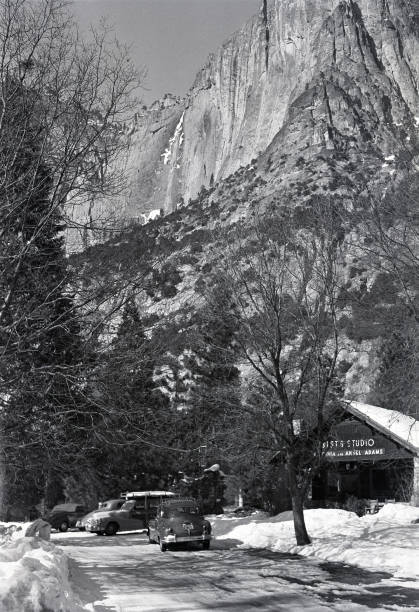 Yosemite Falls towering above Best's Studio, the studio of Virginia and Ansel Adams in Yosemite Valley, Yosemite National Park, California, USA in 1950. Scanned film with grain.
