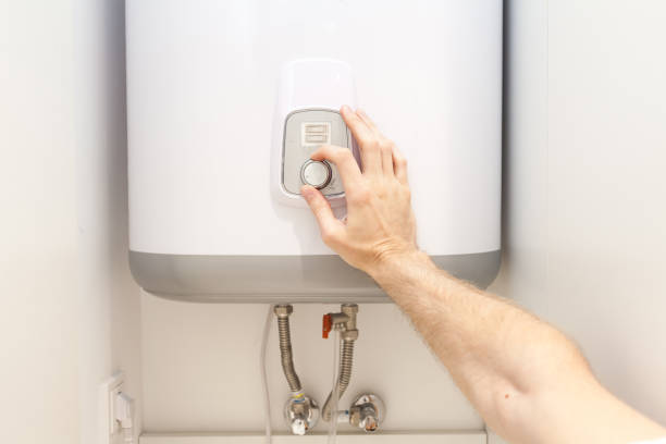 Close-up of man hands setting the temperature of water in Electric Boiler Close-up of man hands setting the temperature of water in Electric Boiler turn knob stock pictures, royalty-free photos & images