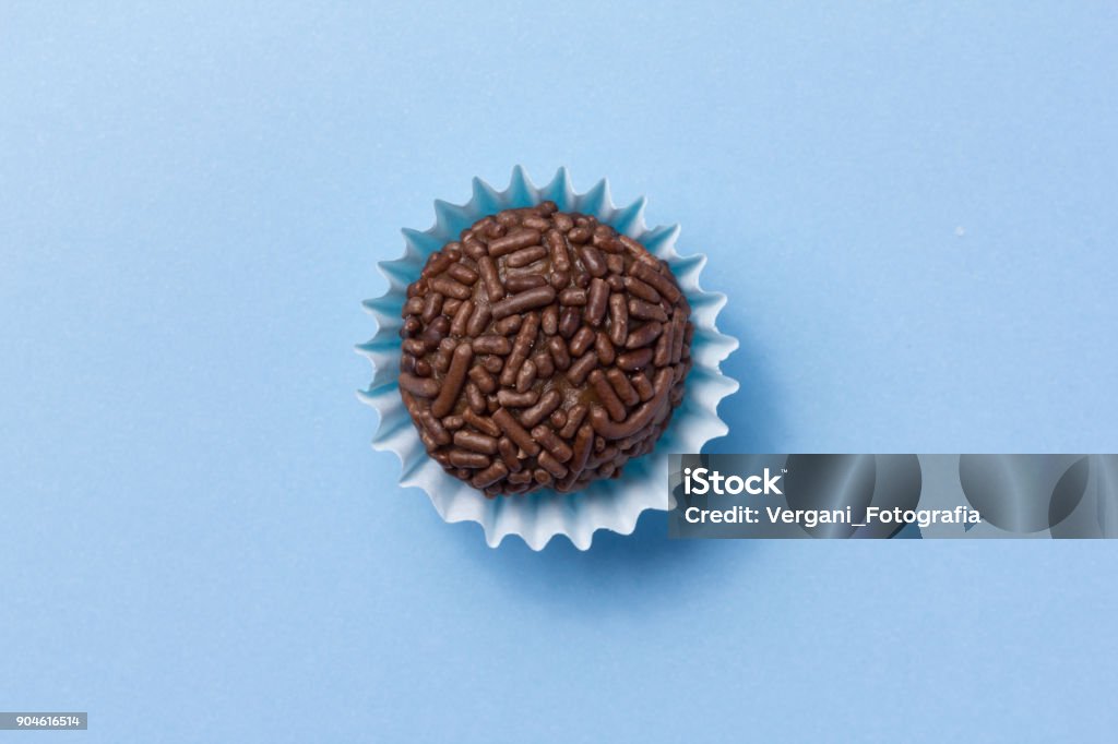 Brigadeiro es una trufa de chocolate de Brasil. Cacao y chispitas de chocolate. Dulce de fiesta de cumpleaños de los niños. Vista superior de caramelo en el fondo azul. - Foto de stock de Brigadeiro - Dulce libre de derechos