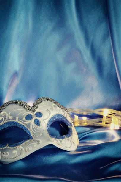 istock Image of elegant venetian mask over blue silk background. 904616934